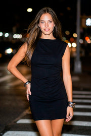 Vestido corto de fit ajustado, sin mangas, cuello redondo y detalle de plisado en costado. Cierre posterior con cremallera visible en contraste.