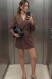 Vestido blazer corto cruzado de fit ajustado, manga larga, con hombreras y solapa. Cruce frontal con doble botón en contraste, bolsillos delanteros con cartera, vivo decorativo frontal y cut out en costados y espalda.