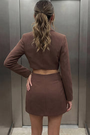 Vestido blazer corto cruzado de fit ajustado, manga larga, con hombreras y solapa. Cruce frontal con doble botón en contraste, bolsillos delanteros con cartera, vivo decorativo frontal y cut out en costados y espalda.