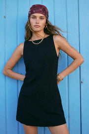 Vestido corto básico de fit recto, sin mangas, cuello barco, escote en espalda y cierre posterior con cremallera oculta.