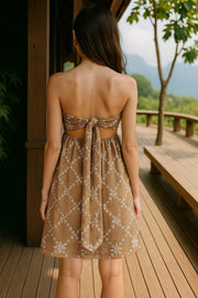 Vestido bordado strapless mini, escote recto elástico con fruncido, cut out en espalda con detalle de nudo amarrable.