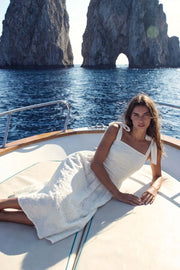 Vestido midi de bordado floral con perforado, tirantes con nudo amarrable, escote recto con cortes y plisados decorativos, corte en a, plisados en cintura con corte frontal en v y fruncido en espalda.