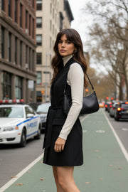 Vestido chaleco corto de fit recto, con solapa, bolsillos frontales con cartera, trabillas y cinturón amarrable del mismo tejido. Cierre frontal con doble cruce de botones.