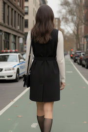 Vestido chaleco corto de fit recto, con solapa, bolsillos frontales con cartera, trabillas y cinturón amarrable del mismo tejido. Cierre frontal con doble cruce de botones.