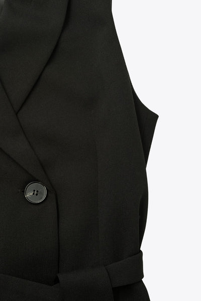 Vestido chaleco corto de fit recto, con solapa, bolsillos frontales con cartera, trabillas y cinturón amarrable del mismo tejido. Cierre frontal con doble cruce de botones.