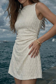 Vestido corto de cuello barco, sin mangas, plisados laterales en cintura, corte en a y detalle de textura en tejido.
