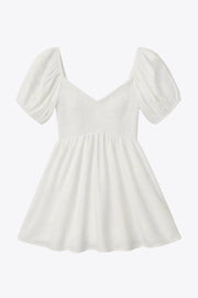 Vestido corto bordado, de talle fruncido, escote v, manga corta abullonada con rib elástico en bordes y corte en a con olanes en bajo.