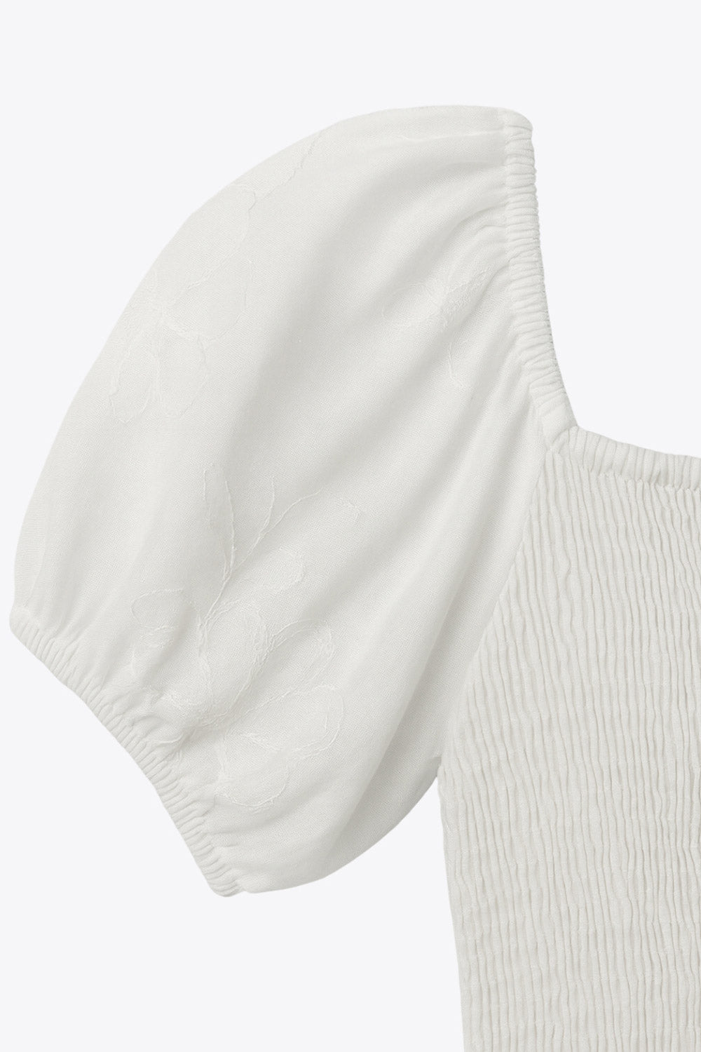 Vestido corto bordado, de talle fruncido, escote v, manga corta abullonada con rib elástico en bordes y corte en a con olanes en bajo.