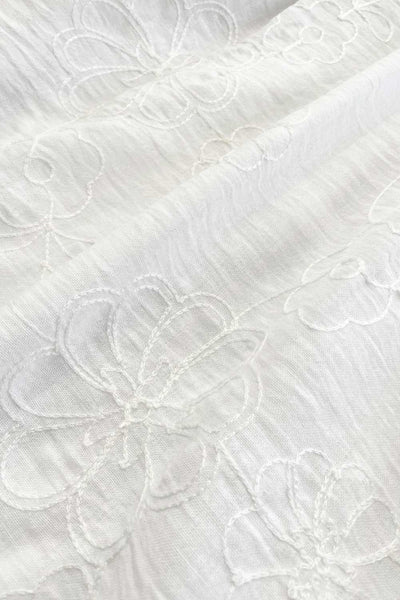 Vestido corto bordado, de talle fruncido, escote v, manga corta abullonada con rib elástico en bordes y corte en a con olanes en bajo.