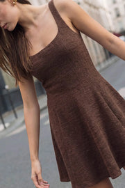 Vestido corto de bouclé, corte en a, escote cuadrado, sin mangas, pinzas frontales con cortes y olanes en bajo.