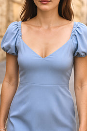 Vestido corto de fit ajustado, manga corta abullonada con rib elástico en bordes, corte en cintura, cut out en espalda con doble elástico plisado y cierre posterior con cremallera oculta.