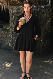 Vestido corto de fit fluido, escote v, manga 3/4 abullonada con rib elástico en puños y plisados decorativos laterales con elástico.