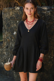 Vestido corto de fit fluido, escote v, manga 3/4 abullonada con rib elástico en puños y plisados decorativos laterales con elástico.