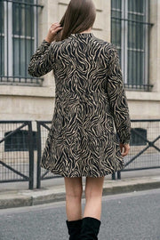 Vestido corto camisero estampado, de manga larga con puño abotonado, corte en a, escote v y capas con olanes en bajo.