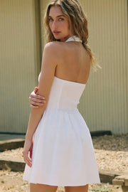 Vestido corto de cuello halter, sin mangas, escote recto, corte en a, corte v en cintura con plisados y fruncido en espalda.