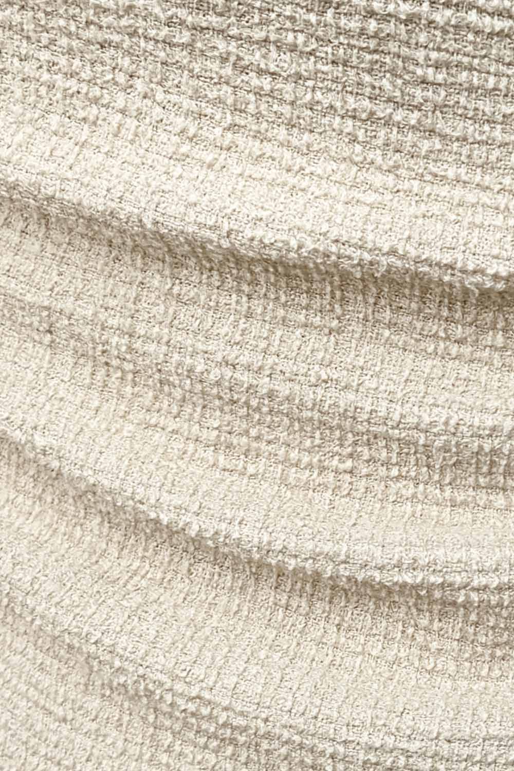 Vestido corto de cuello barco, sin mangas, plisados laterales en cintura, corte en a, rib en bordes y detalle de textura en tejido.