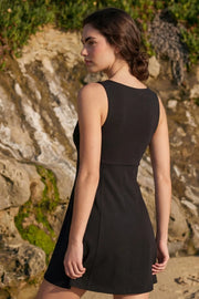 Vestido corto de corte en a, sin mangas, escote v con cortes y lazo decorativo frontal.