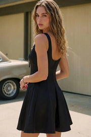 Vestido corto de fit ajustado, cuello barco, sin mangas, corte en a, pinzas y cortes decorativos. Detalle de cut out en escote con lazos amarrables.