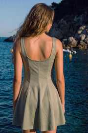 Vestido corto de fit ajustado, cuello barco, sin mangas, corte en a, pinzas y cortes decorativos. Detalle de cut out en escote con lazos amarrables.
