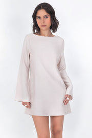 Vestido corto de fit recto, cuello barco, manga larga con puño amplio, escote en espalda y lazo amarrable posterior.