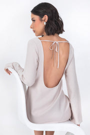 Vestido corto de fit recto, cuello barco, manga larga con puño amplio, escote en espalda y lazo amarrable posterior.