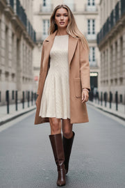 Vestido corto de cuello barco, sin mangas, pinzas frontales, escote en espalda y corte en a con olanes en bajo. Detalle de textura en tejido.