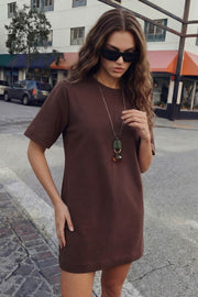 Vestido camiseta corto de fit oversized, cuello redondo, manga corta y detalle de corte decorativo frontal.