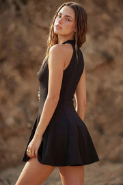 Vestido corto de fit ajustado, escote v, sin mangas, pinzas frontales, corte en a y olanes en bajo. Cierre posterior con cremallera oculta.