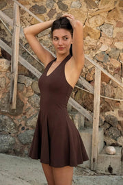 Vestido corto de fit ajustado, escote v, sin mangas, pinzas frontales, corte en a y olanes en bajo. Cierre posterior con cremallera oculta.