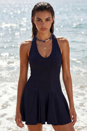 Vestido corto canalé, de fit ajustado, escote v, sin mangas, pinzas frontales, corte en a y olanes en bajo. Cierre posterior con cremallera oculta.