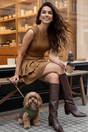 Vestido corto de pana, fit ajustado, cuello redondo, sin mangas, pinzas frontales, corte v frontal en cadera y doble capa de olanes en bajo. Cierre posterior con cremallera oculta.