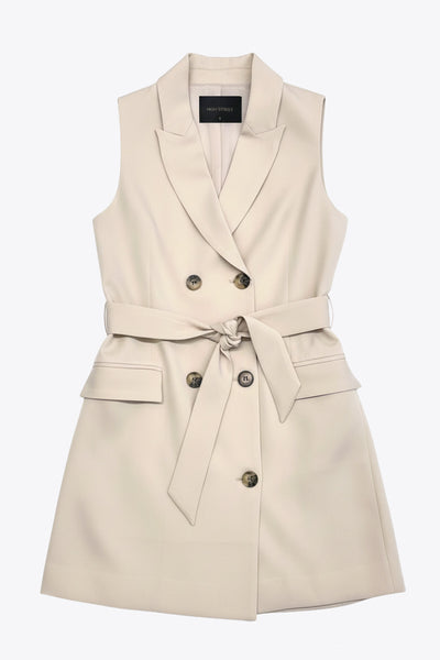 Vestido chaleco con solapa y con doble cruce de botón en contraste. Detalle de bolsillos frontales con cartera, trabillas y cinturón amarrable del mismo tejido.