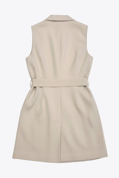 Vestido chaleco con solapa y con doble cruce de botón en contraste. Detalle de bolsillos frontales con cartera, trabillas y cinturón amarrable del mismo tejido.