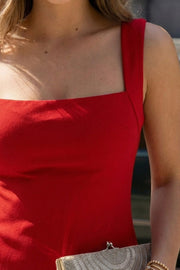 Vestido corto básico de fit ajustado, sin mangas, escote cuadrado, abertura frontal en bajo y cierre posterior con cremallera oculta.