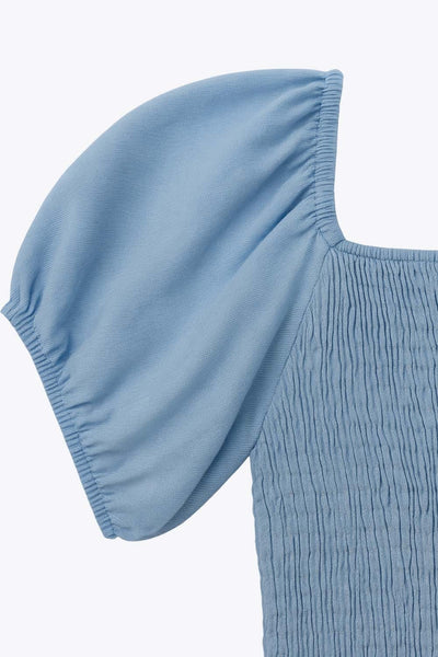 Vestido corto de lino, talle fruncido, escote v, manga corta abullonada con rib elástico en bordes y corte en a con olanes en bajo.