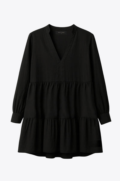 Vestido corto camisero de manga larga abullonada con puño abotonado, corte en a, escote v con costuras, cuello mao y capas con olanes en bajo.