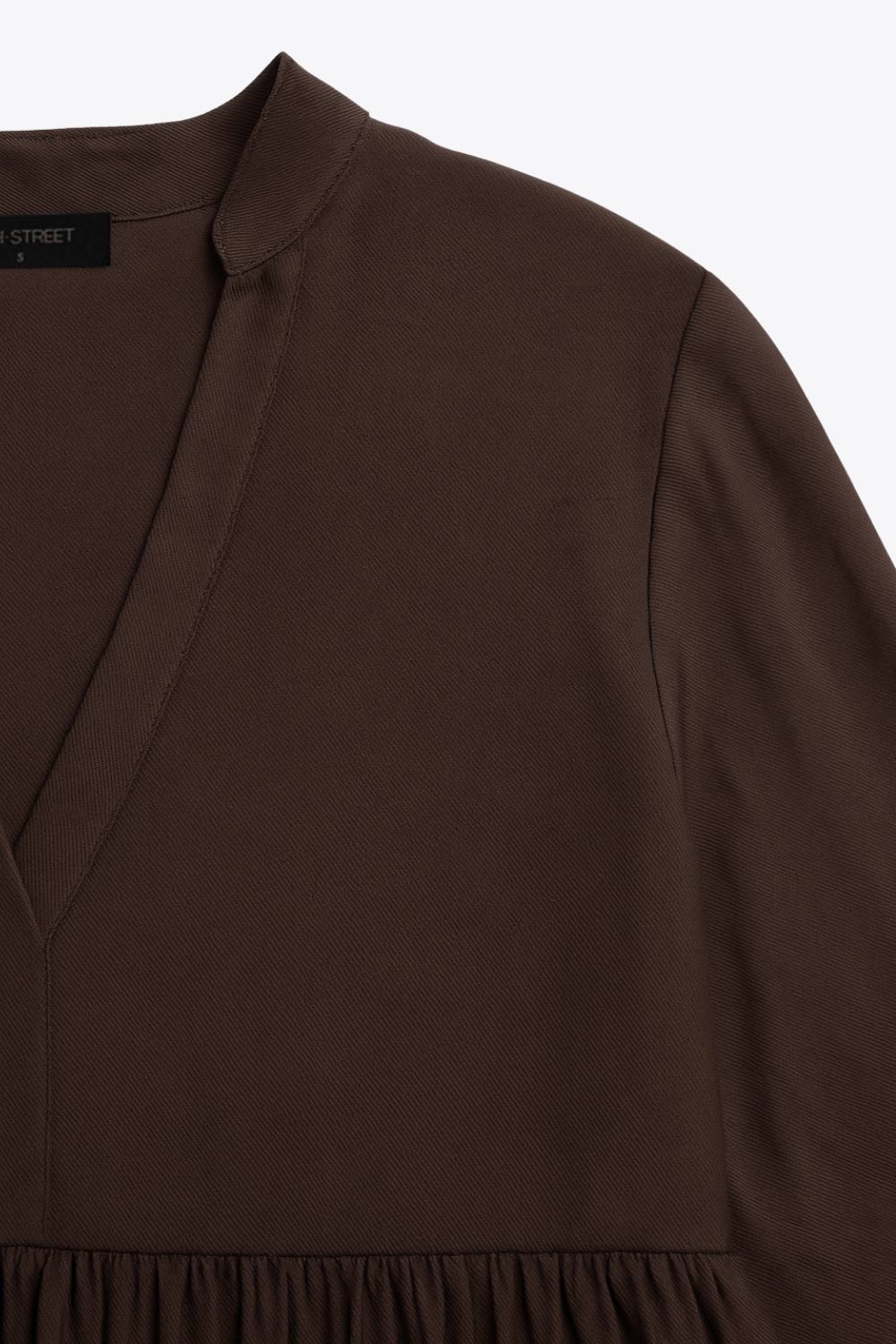 Vestido corto camisero de manga larga abullonada con puño abotonado, corte en a, escote v con costuras, cuello mao y capas con olanes en bajo.