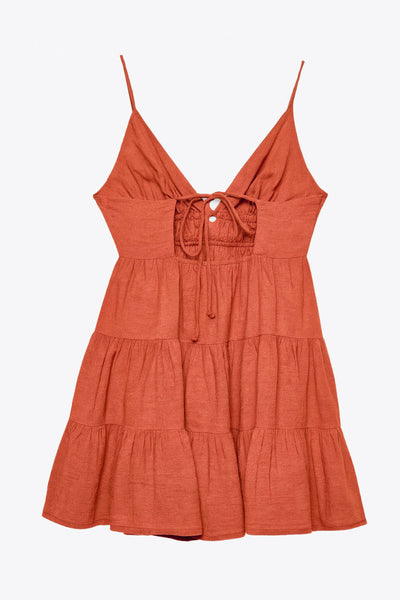 Vestido corto de escote v, corte en a con capas de olanes en bajo, rib elástico en cintura, tirantes delgados con lazado ajustable posterior y escote en espalda.