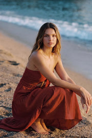 Vestido midi strapless de escote corazón con nudo amarrable, cut out frontal, cintura elástica, detalle de capas de olanes en bajo y fruncido en espalda.
