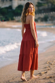 Vestido midi strapless de escote corazón con nudo amarrable, cut out frontal, cintura elástica, detalle de capas de olanes en bajo y fruncido en espalda.