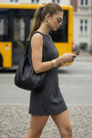 Vestido básico corto de estampado rayas, fit recto, pinzas frontales, sin mangas, cuello barco y lazo amarrable en cintura. Cierre posterior con cremallera oculta.