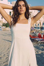 Vestido largo de fit recto, escote redondeado, corte frontal, tirantes elásticos con plisados y escote en espalda con lazado ajustable. Abertura frontal en bajo, rib elástico y cremallera oculta posterior.