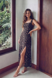 Vestido largo de estampado floral, fit recto, escote redondeado, corte frontal, tirantes elásticos con plisados y escote en espalda con lazado ajustable. Abertura frontal en bajo, rib elástico y cremallera oculta posterior.
