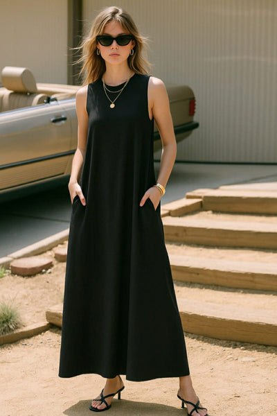 Vestido midi básico de fit fluido, corte en a, sin mangas, bolsillos delanteros y cuello redondo. Cierre posterior con botón y ojal.