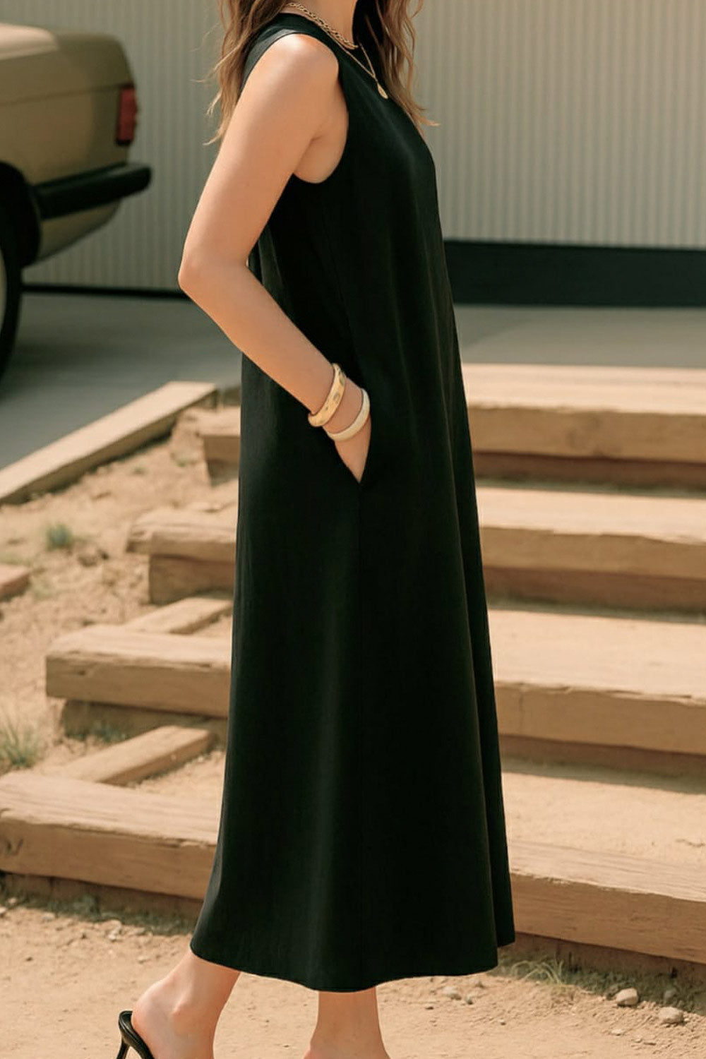 Vestido midi básico de fit fluido, corte en a, sin mangas, bolsillos delanteros y cuello redondo. Cierre posterior con botón y ojal.