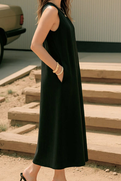 Vestido midi básico de fit fluido, corte en a, sin mangas, bolsillos delanteros y cuello redondo. Cierre posterior con botón y ojal.