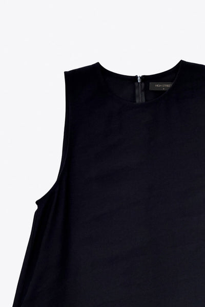 Vestido midi básico de fit fluido, corte en a, sin mangas, bolsillos delanteros y cuello redondo. Cierre posterior con botón y ojal.