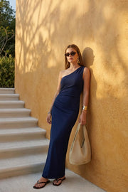 Vestido maxi asimétrico de un hombro, fit ajustado, escote diagonal, sin mangas, plisados en costado y abertura lateral en bajo.