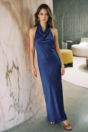 Vestido largo de fit fluido, cuello alto halter fluido, sin mangas, escote en espalda y lazo amarrable posterior.