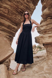 Vestido largo de cuello halter, sin mangas, escote recto, corte en a, corte v en cintura con plisados y fruncido en espalda.